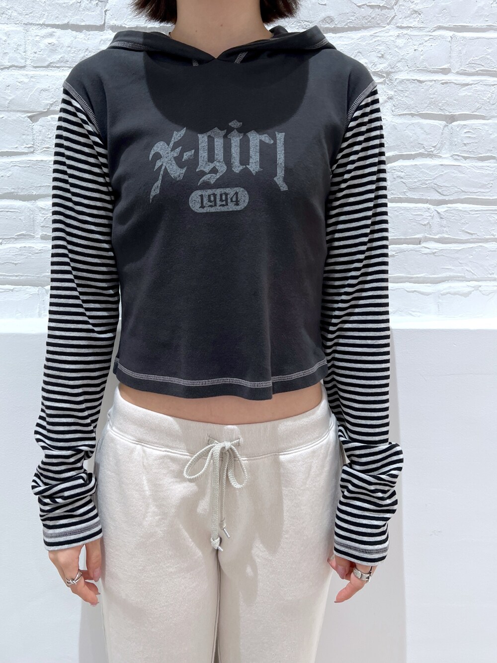 グレー系のTシャツ/カットソー、ホワイト系のスウェットパンツ、ブラック系のキャスケットを着用したレディースの秋コーディネートの3枚目の写真