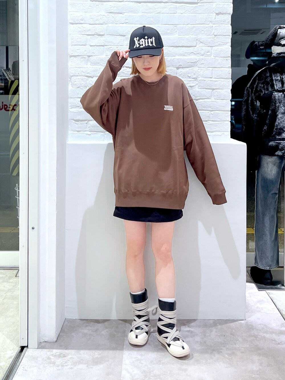 ブラック系のスカート、ブラウン系のスウェット、ブラック系のキャップを着用したレディースの秋コーディネートの2枚目の写真