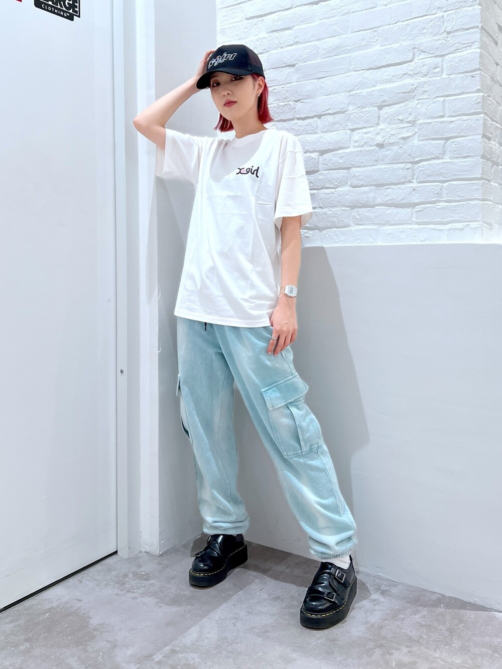 ホワイト系のTシャツ/カットソー、ブルー系のスウェットパンツ、ブラック系のキャップを着用したレディースの春コーディネートの2枚目の写真