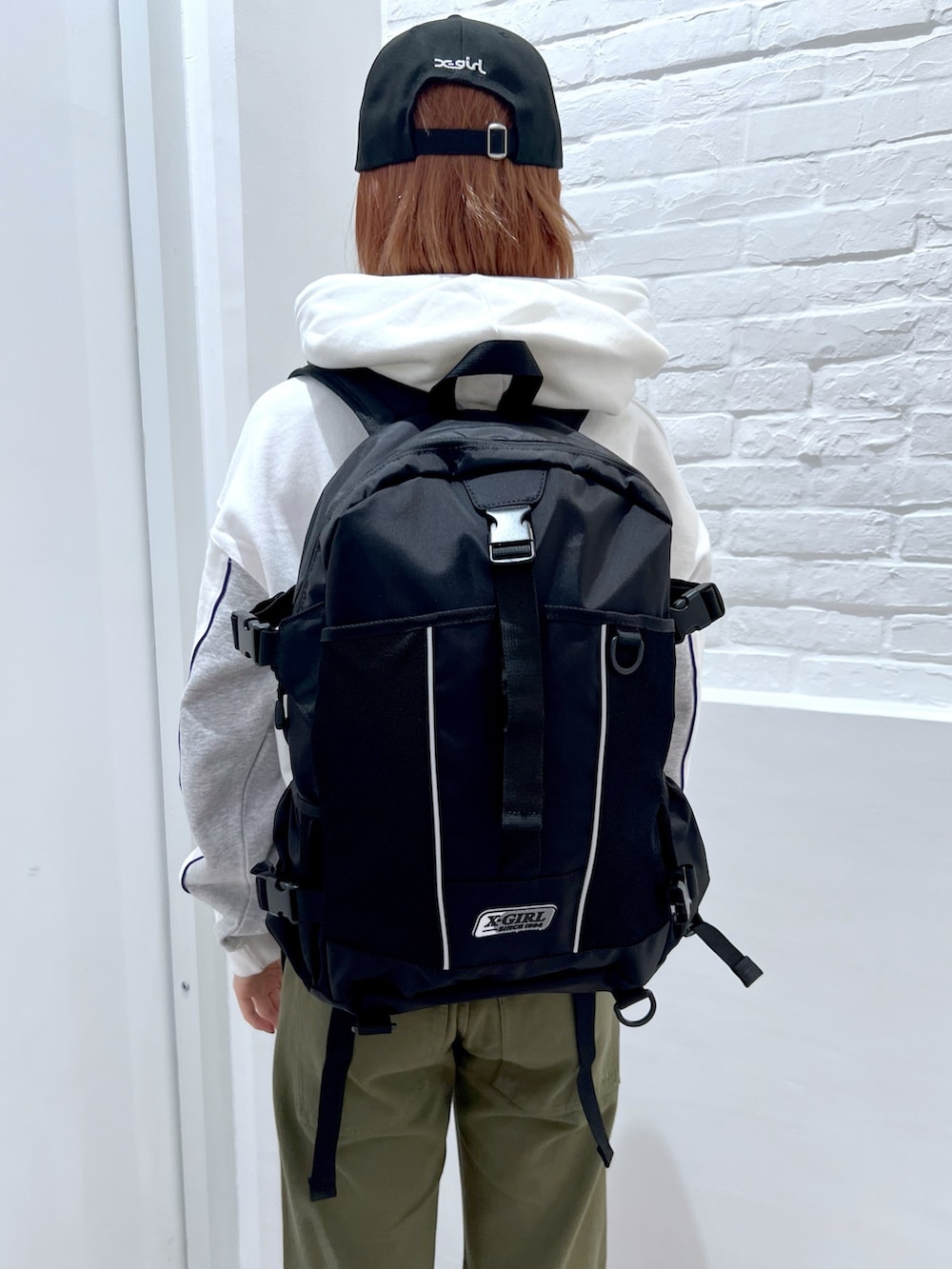 グリーン系のその他パンツ、ホワイト系のパーカー、ブラック系のバックパック/リュックを着用したレディースの冬コーディネートの7枚目の写真