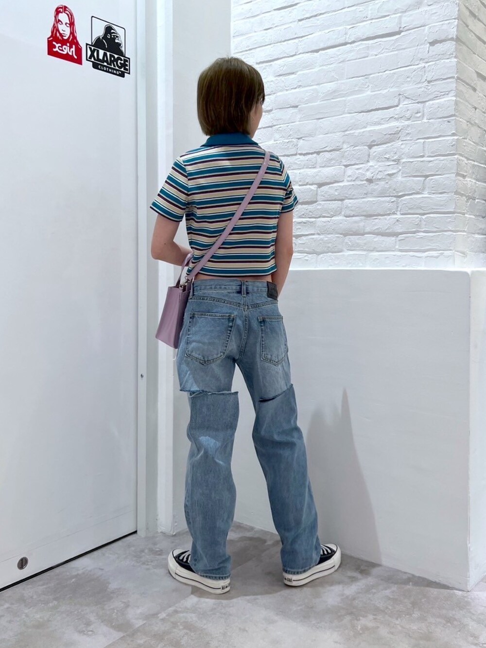 ブルー系のデニムパンツ、ブルー系のシャツ/ブラウス、ピンク系のショルダーバッグを着用したレディースの春コーディネートの2枚目の写真