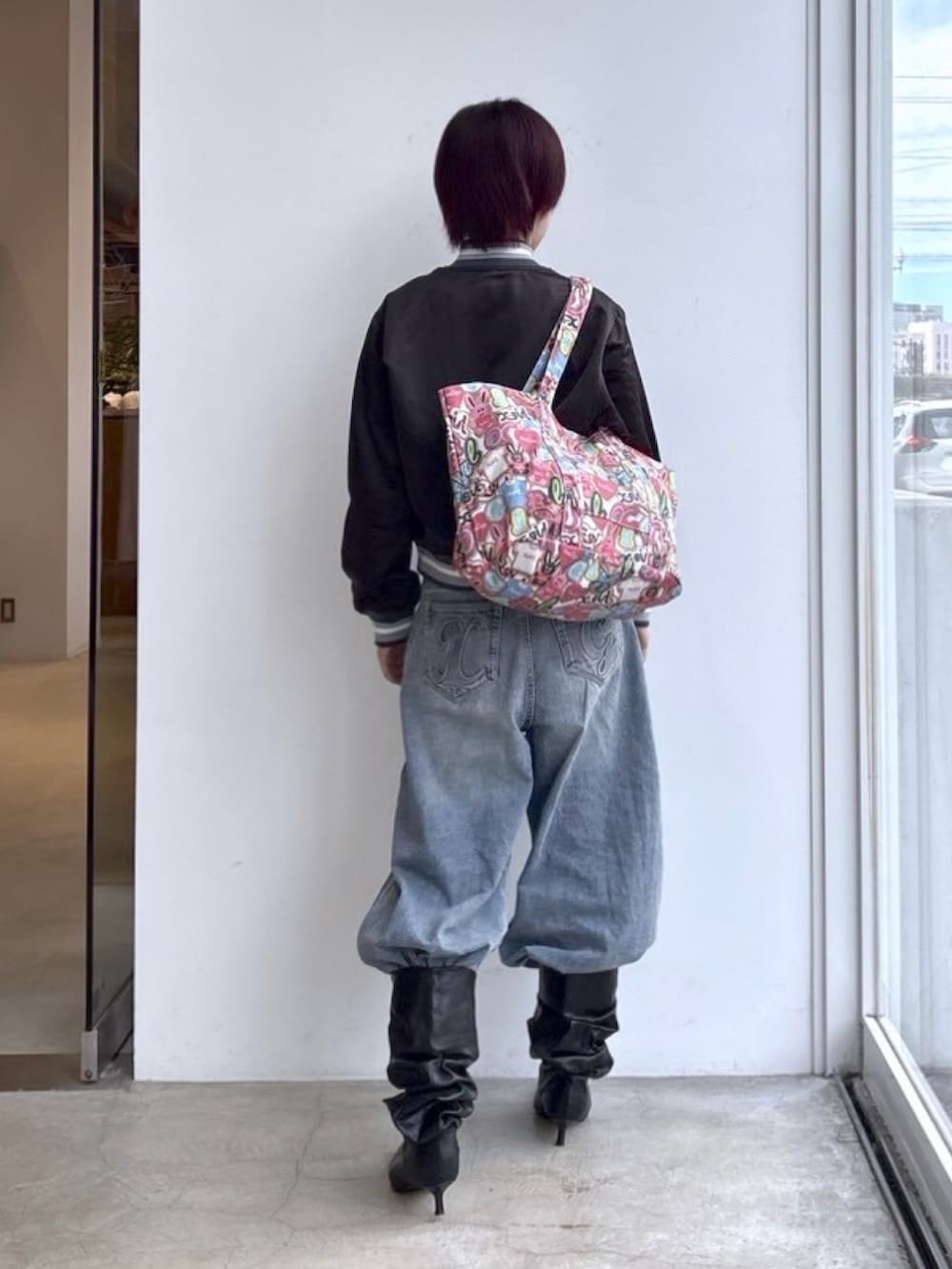 ブルー系のデニムパンツ、その他のトートバッグ、ブラック系のナイロンジャケットを着用したレディースの秋コーディネートの2枚目の写真