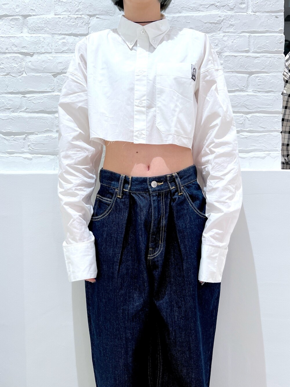 ブルー系のデニムパンツ、ホワイト系のシャツ/ブラウス、ブラック系のパーカーを着用したレディースの春コーディネートの4枚目の写真