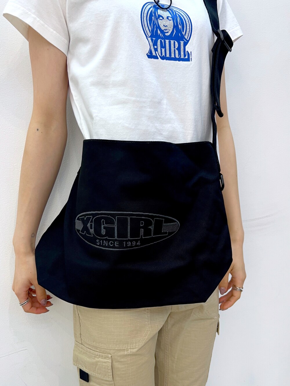 ベージュ系のその他パンツ、ブラック系のショルダーバッグ、ホワイト系のTシャツ/カットソーを着用したレディースの夏コーディネートの5枚目の写真