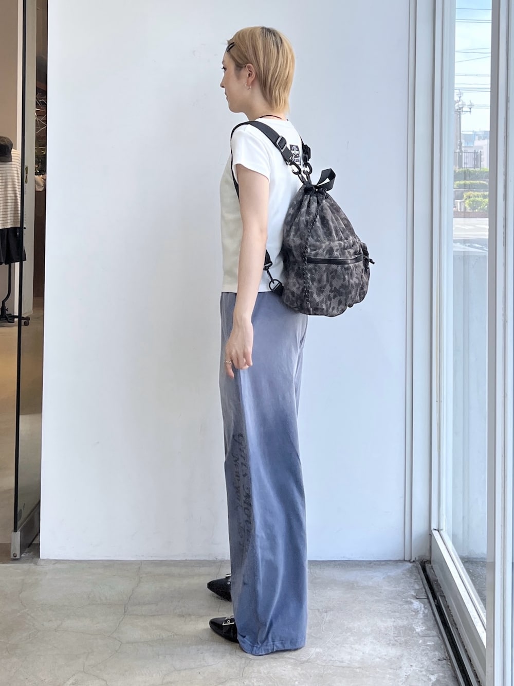 ブルー系のその他パンツ、ホワイト系のTシャツ/カットソー、ベージュ系のバックパック/リュックを着用したレディースの夏コーディネートの2枚目の写真