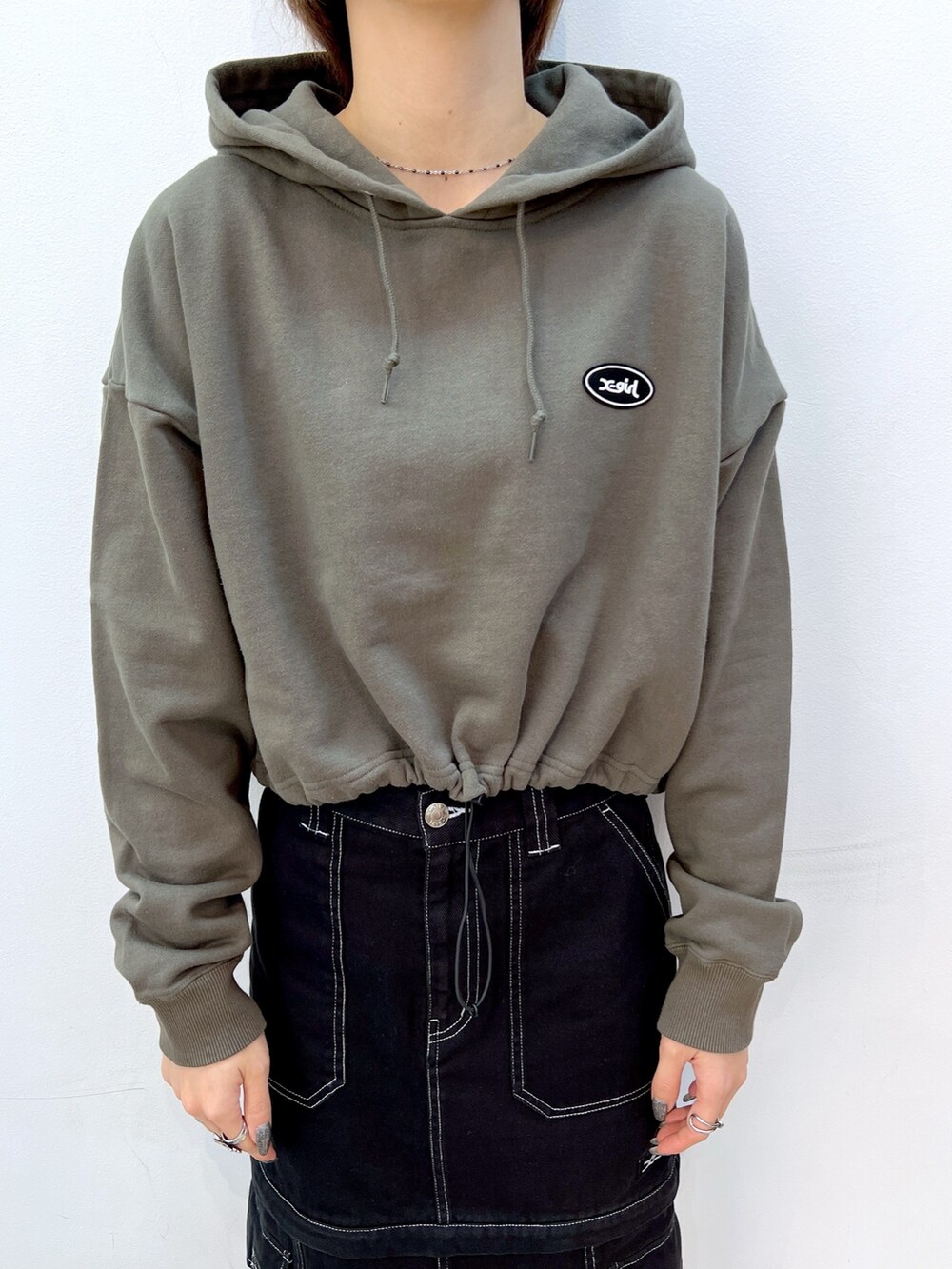 ブラック系のスカート、グリーン系のパーカー、ブラック系のショルダーバッグを着用したレディースの冬コーディネートの3枚目の写真