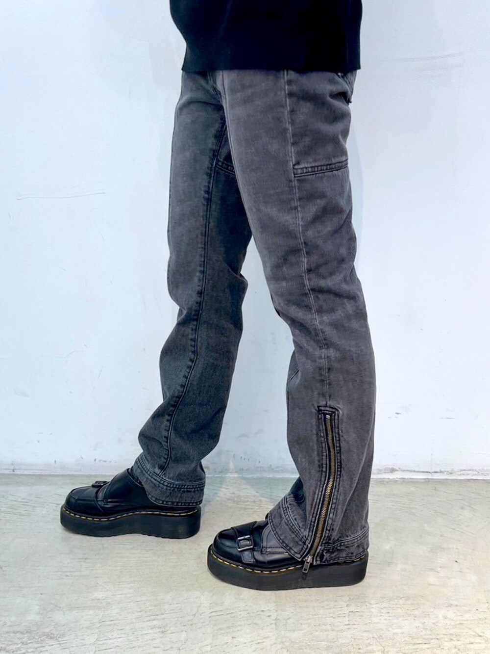 ブラック系のデニムパンツ、グレー系のマウンテンパーカー、ブラック系のニット/セーターを着用したレディースの秋コーディネートの7枚目の写真