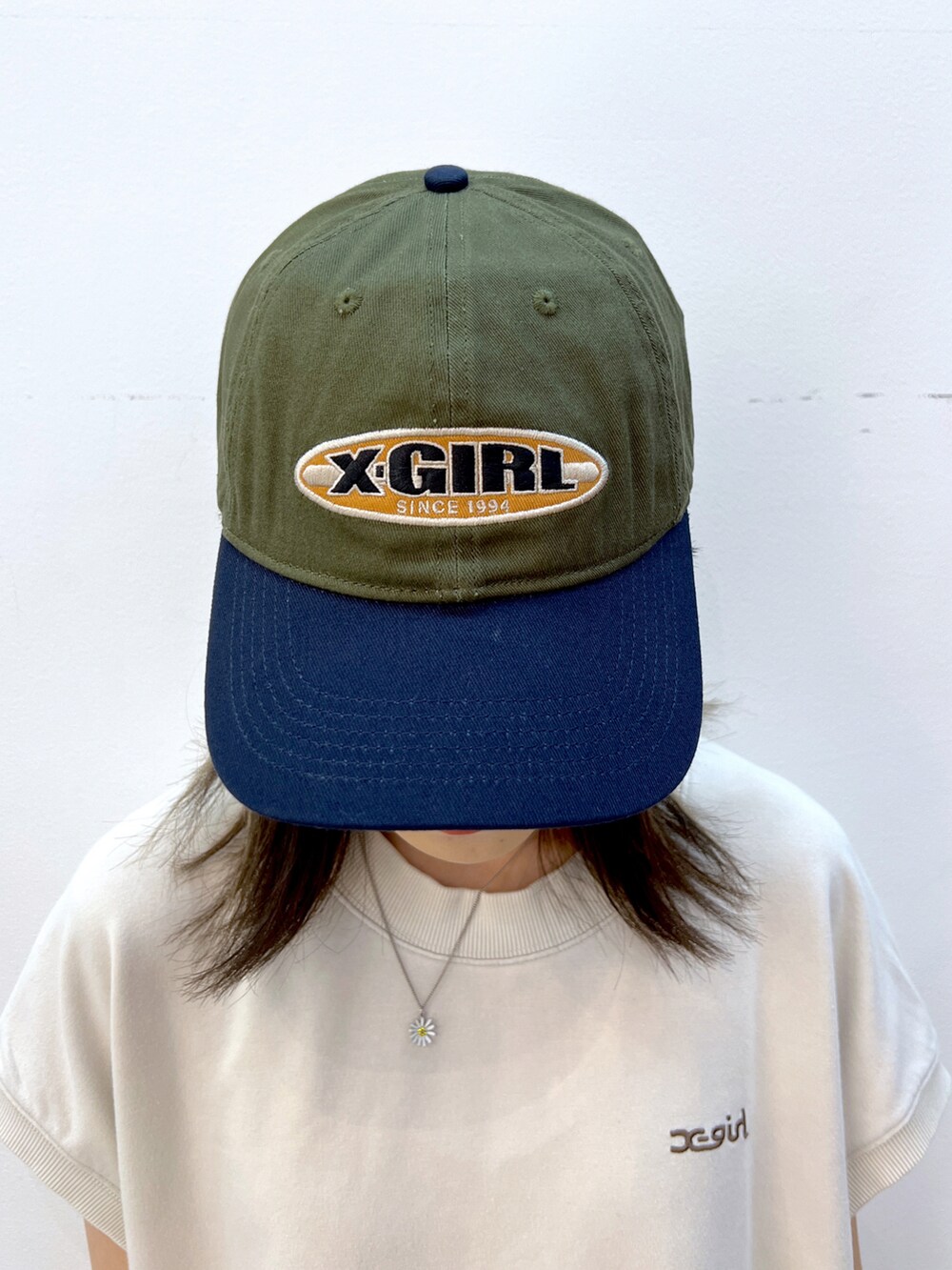 ホワイト系のワンピース、ブラック系のトートバッグ、グリーン系のキャップを着用したレディースの夏コーディネートの4枚目の写真