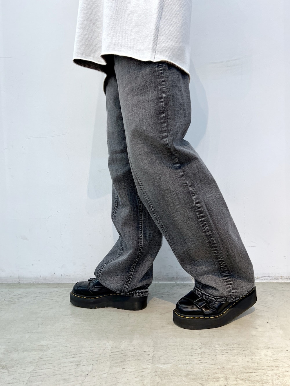 ブラック系のデニムパンツ、ホワイト系のニット/セーター、ブラック系のブルゾンを着用したレディースの冬コーディネートの8枚目の写真