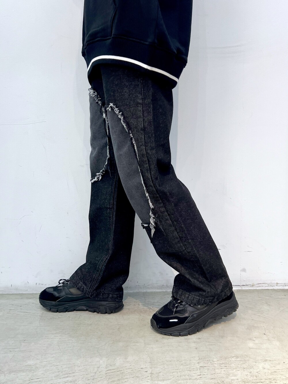 ブラック系のデニムパンツ、ブラック系のスウェット、ブルー系のハットを着用したレディースの冬コーディネートの5枚目の写真