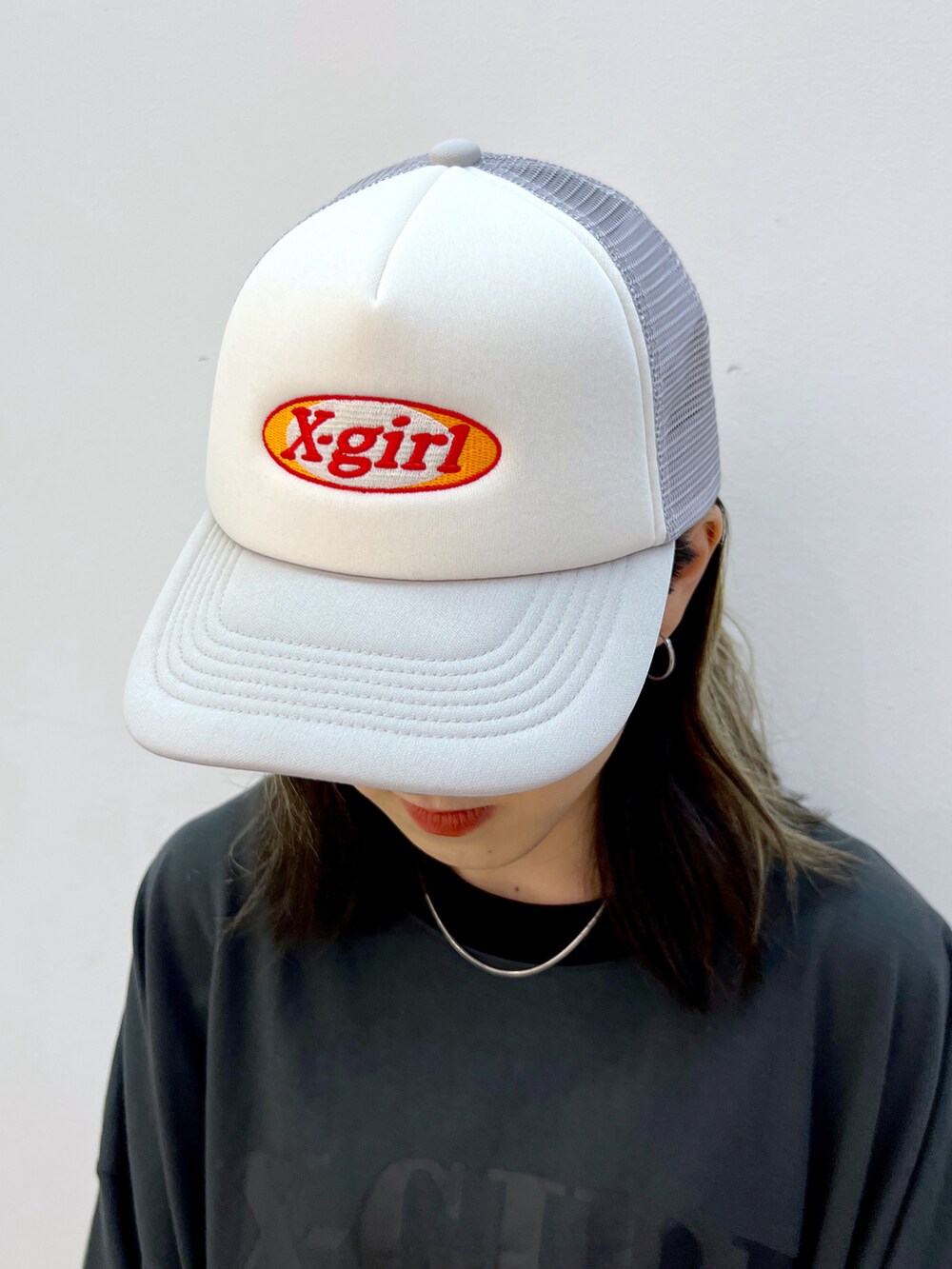 グレー系のワンピース、グレー系のキャップを着用したレディースの夏コーディネートの5枚目の写真