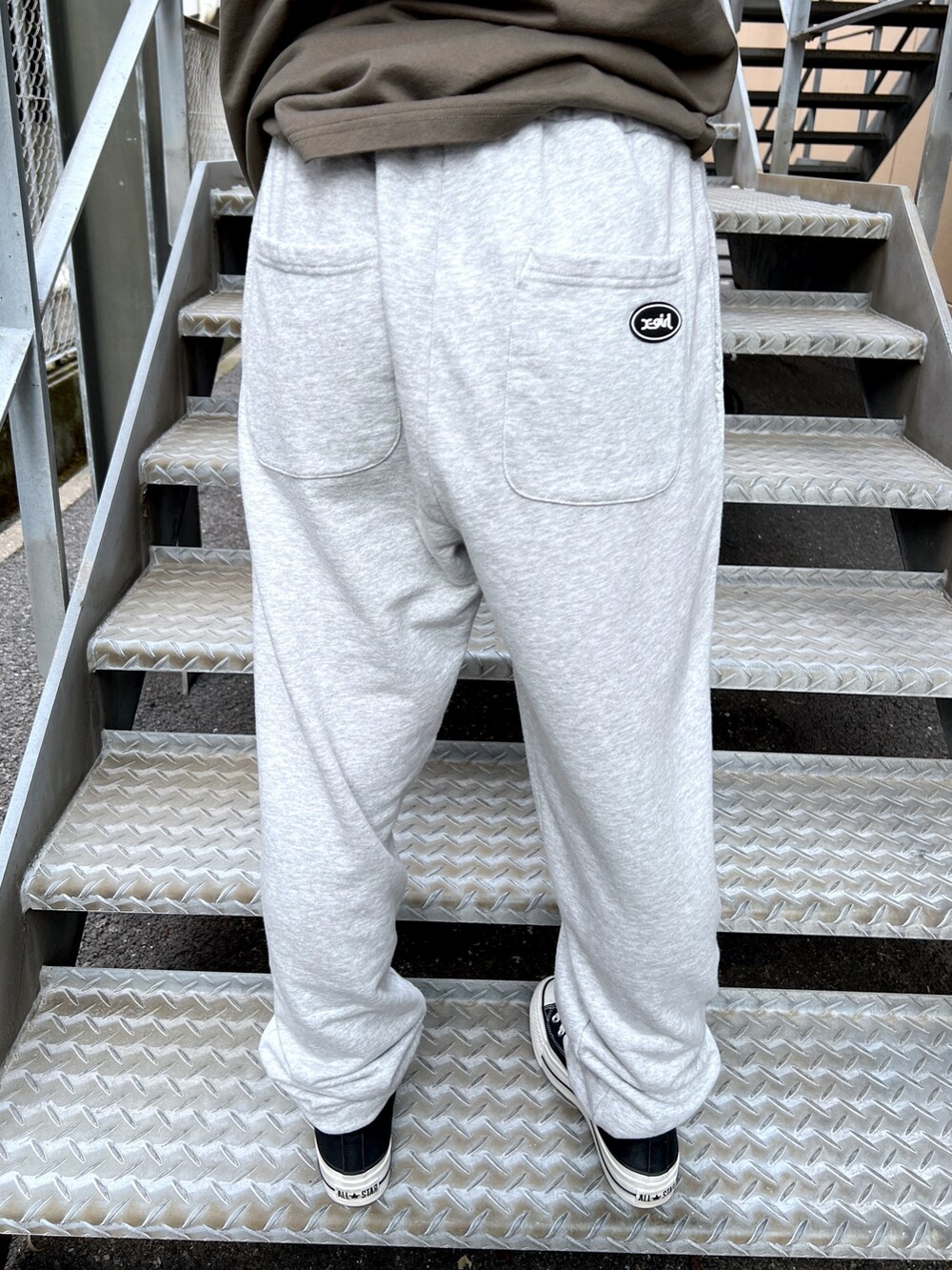 グレー系のスウェットパンツ、グリーン系のTシャツ/カットソー、ブラック系のニットキャップ/ビーニーを着用したレディースの夏コーディネートの6枚目の写真