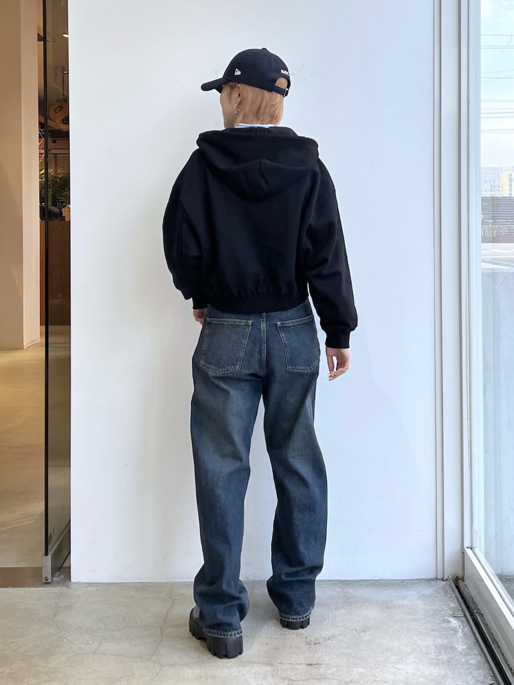 ブルー系のデニムパンツ、ブラック系のパーカー、ブルー系のシャツ/ブラウスを着用したレディースの春コーディネートの2枚目の写真