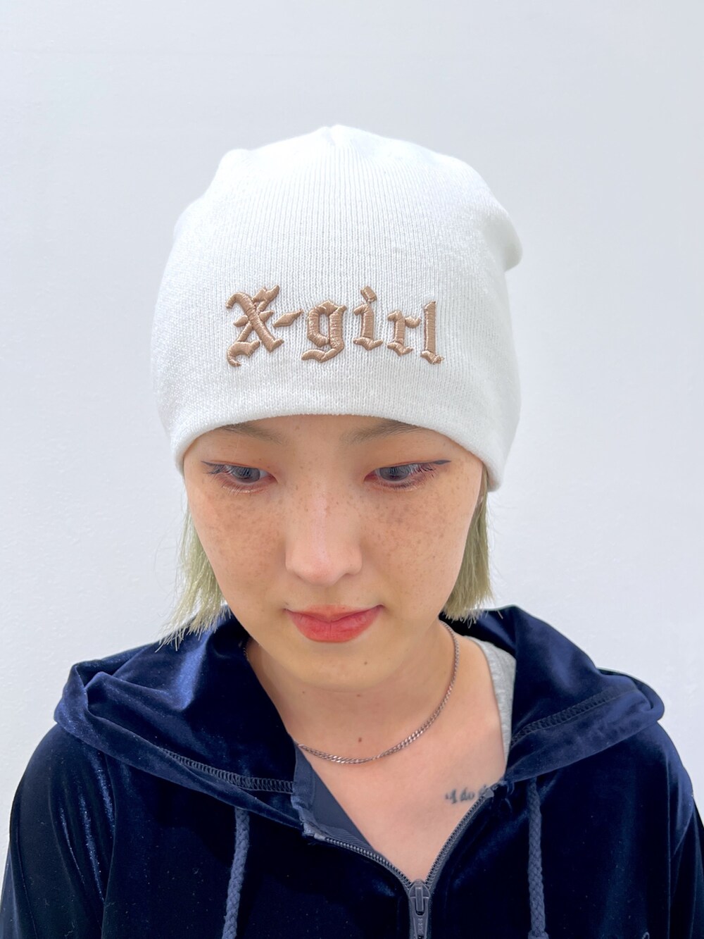 ブルー系のデニムパンツ、ブルー系のパーカー、ホワイト系のニットキャップ/ビーニーを着用したレディースの秋コーディネートの6枚目の写真