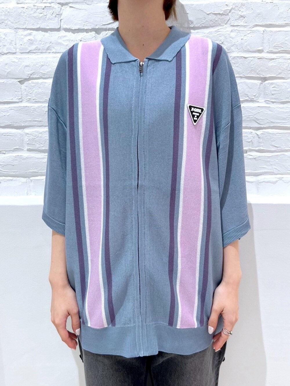 ブラック系のデニムパンツ、ブルー系のポロシャツ、ブラック系のニットキャップ/ビーニーを着用したレディースの春コーディネートの3枚目の写真