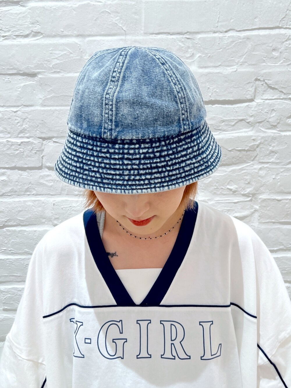 ホワイト系のワンピース、ピンク系のショルダーバッグ、ホワイト系のハットを着用したレディースの春コーディネートの5枚目の写真