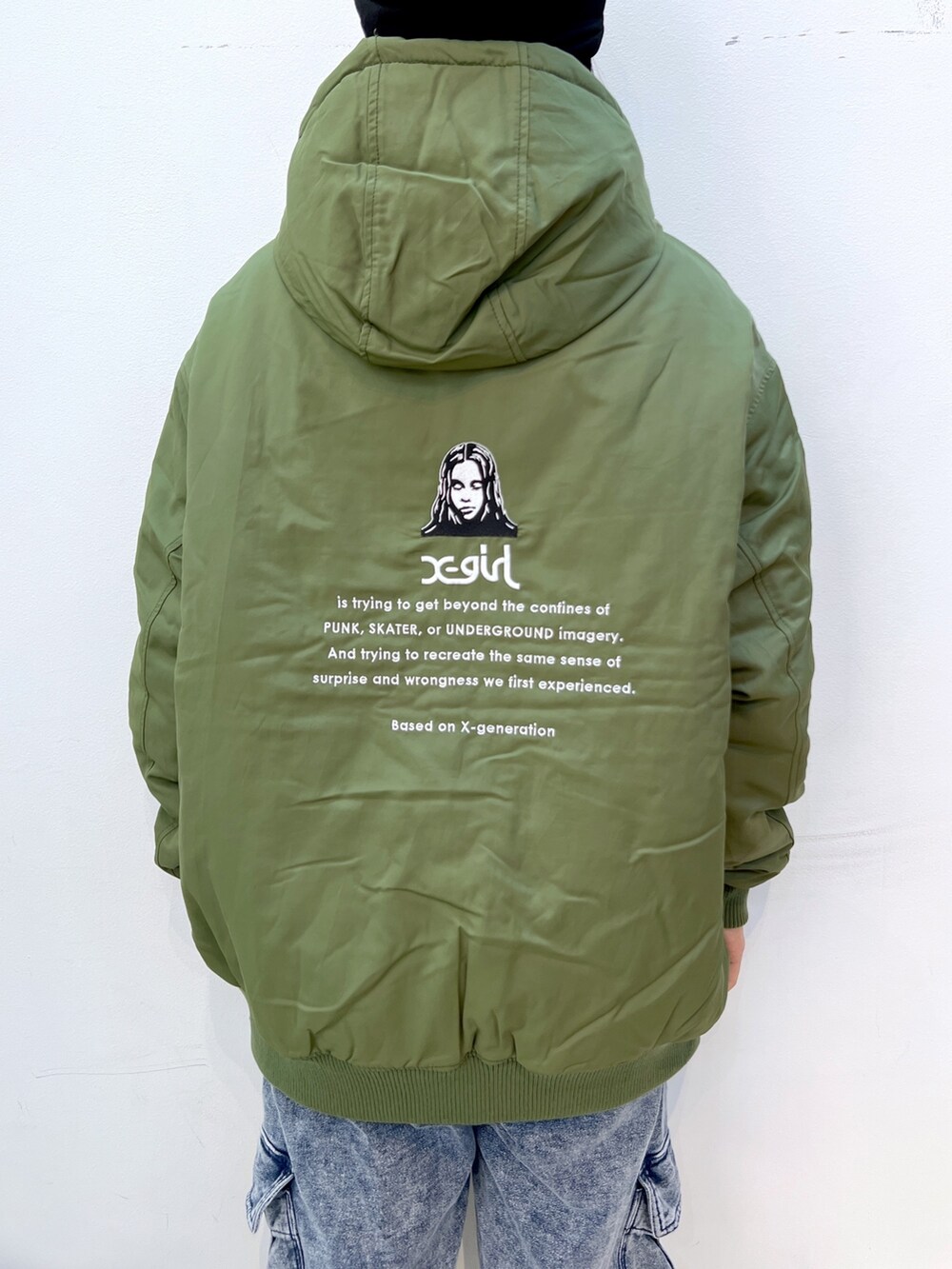 ブルー系のスウェットパンツ、グリーン系のナイロンジャケット、ホワイト系のTシャツ/カットソーを着用したレディースの秋コーディネートの6枚目の写真