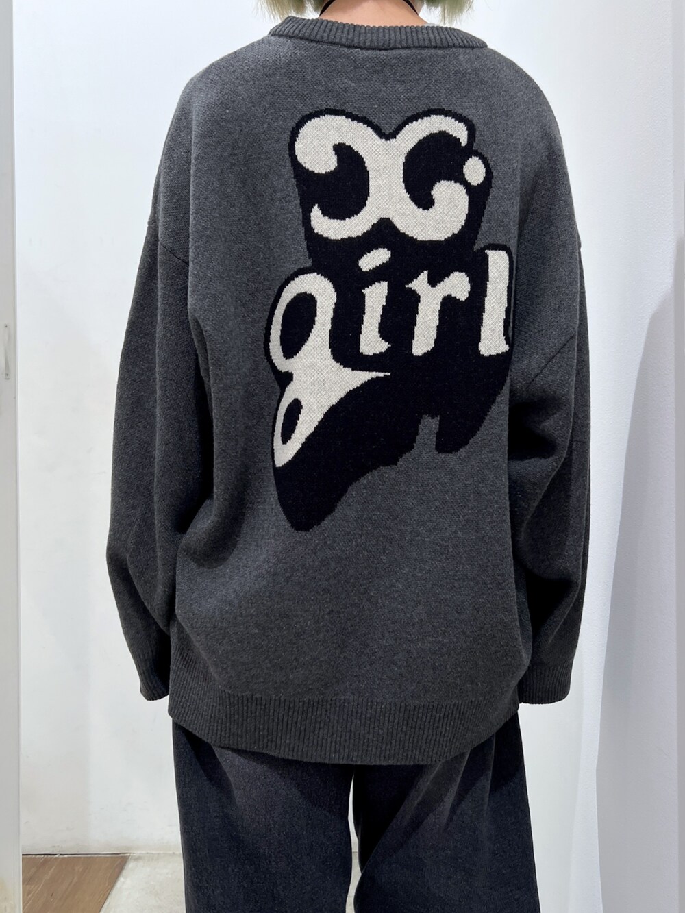 ホワイト系のショルダーバッグ、ブラック系のデニムパンツ、グレー系のニット/セーターを着用したレディースの秋コーディネートの4枚目の写真