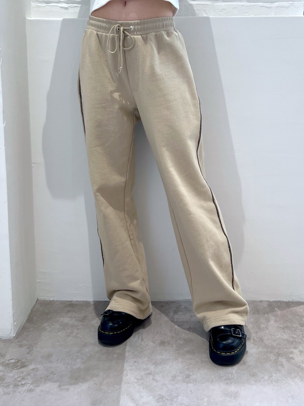 ベージュ系のスウェットパンツ、ホワイト系のカーディガン/ボレロ、ブラック系のキャップを着用したレディースの春コーディネートの4枚目の写真