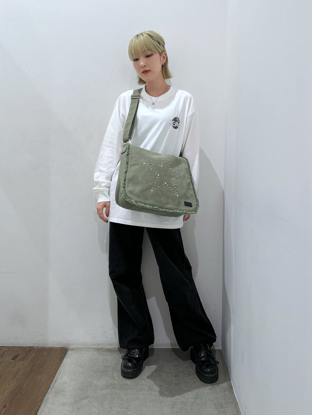 ブラック系のその他パンツ、グリーン系のショルダーバッグ、ホワイト系のTシャツ/カットソーを着用したレディースの秋コーディネートの2枚目の写真