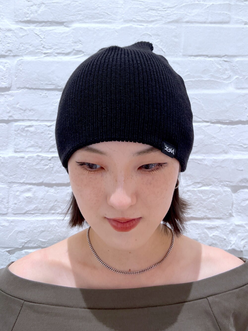 ブラック系のデニムパンツ、グリーン系のTシャツ/カットソー、ブラック系のニットキャップ/ビーニーを着用したレディースの秋コーディネートの6枚目の写真