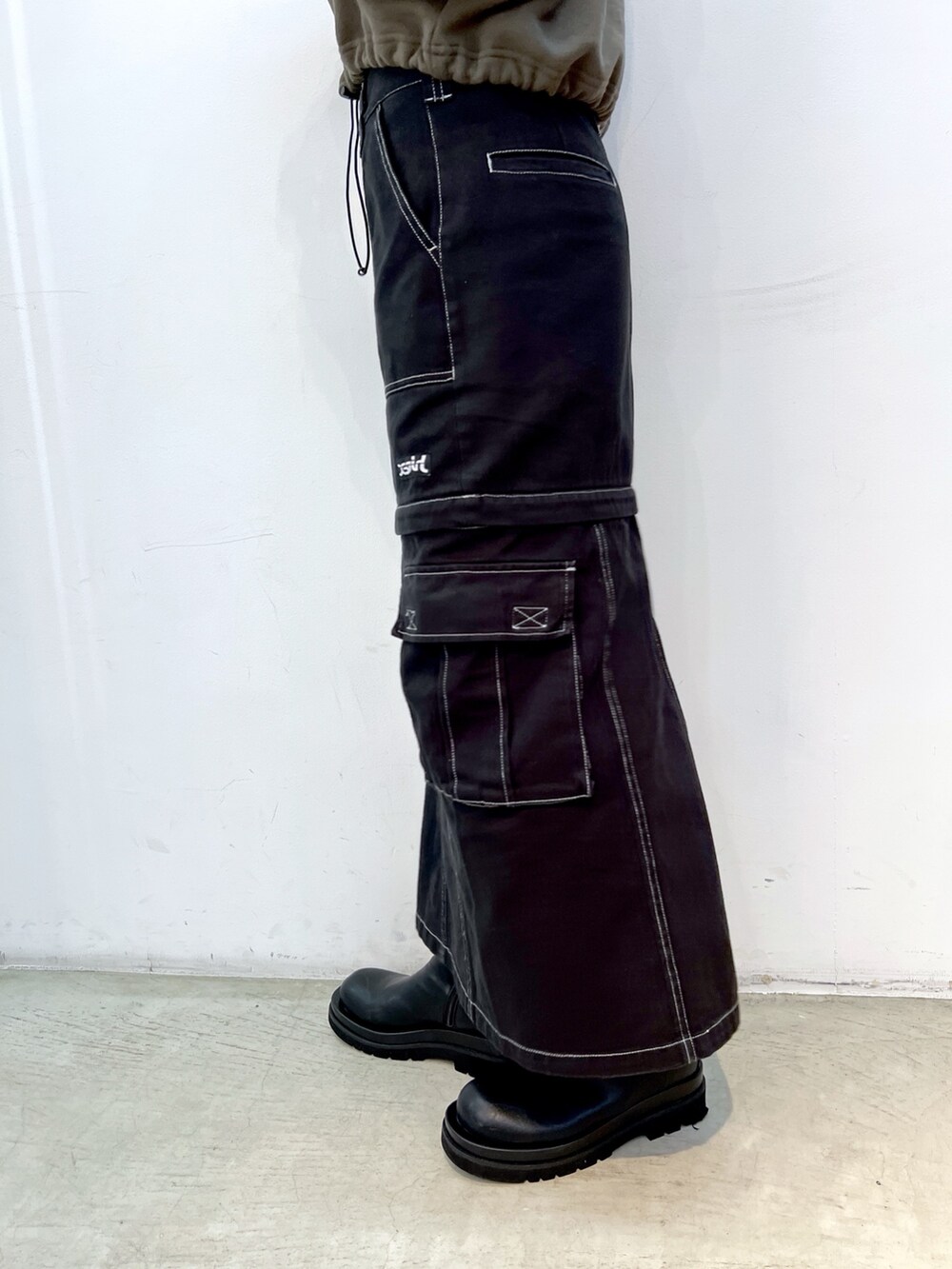 ブラック系のスカート、グリーン系のパーカー、ブラック系のショルダーバッグを着用したレディースの冬コーディネートの5枚目の写真