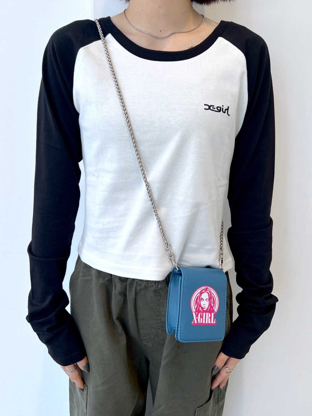 グリーン系のその他パンツ、ブルー系のショルダーバッグ、ホワイト系のTシャツ/カットソーを着用したレディースの秋コーディネートの3枚目の写真