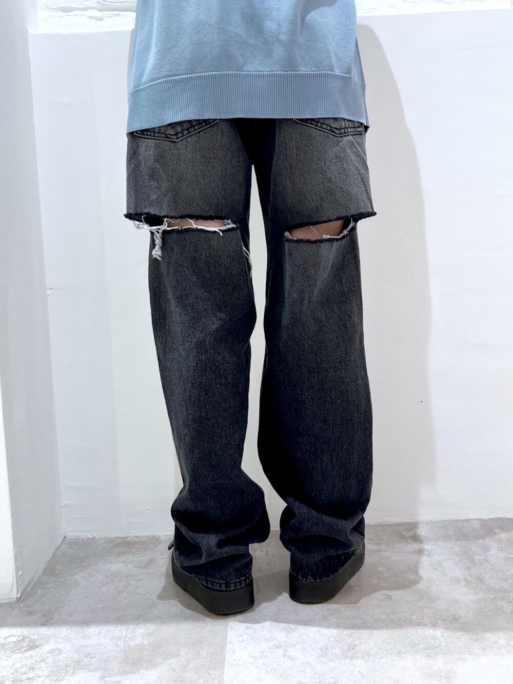 ブラック系のデニムパンツ、ブルー系のポロシャツ、ブラック系のニットキャップ/ビーニーを着用したレディースの春コーディネートの6枚目の写真