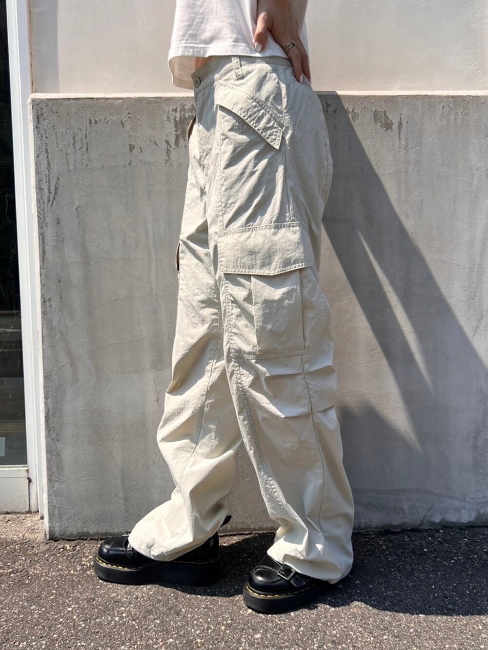 グレー系のカーゴパンツ、ホワイト系のTシャツ/カットソー、グレー系のキャップを着用したレディースの夏コーディネートの5枚目の写真