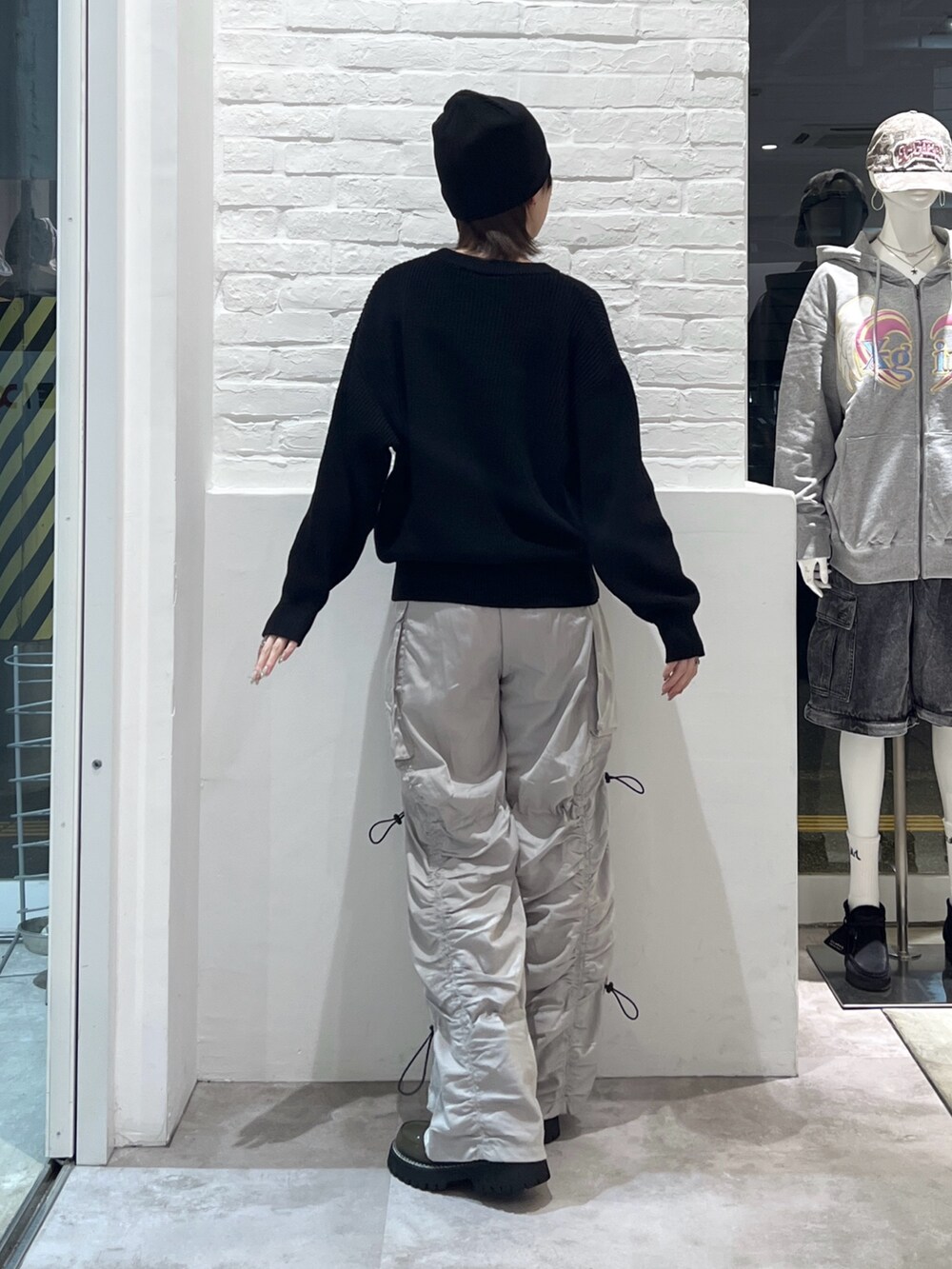 グレー系のその他パンツ、ブラック系のニット/セーター、ブラック系のニットキャップ/ビーニーを着用したレディースの冬コーディネートの2枚目の写真