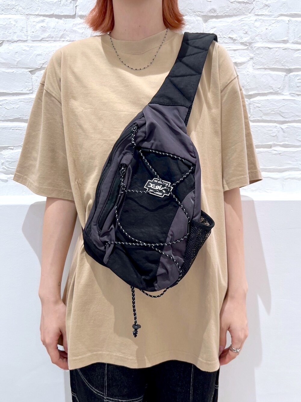 ブラック系のショルダーバッグ、ベージュ系のTシャツ/カットソー、ブラック系のその他パンツを着用したレディースの夏コーディネートの3枚目の写真