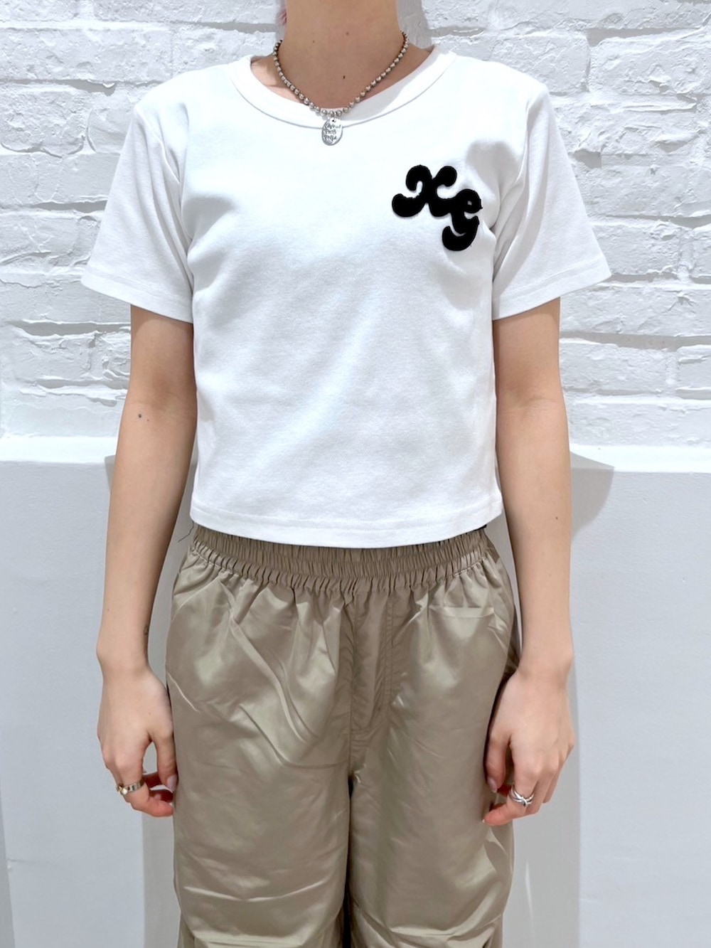 ベージュ系のその他パンツ、ブラック系のハンドバッグ、ホワイト系のTシャツ/カットソーを着用したレディースの春コーディネートの3枚目の写真