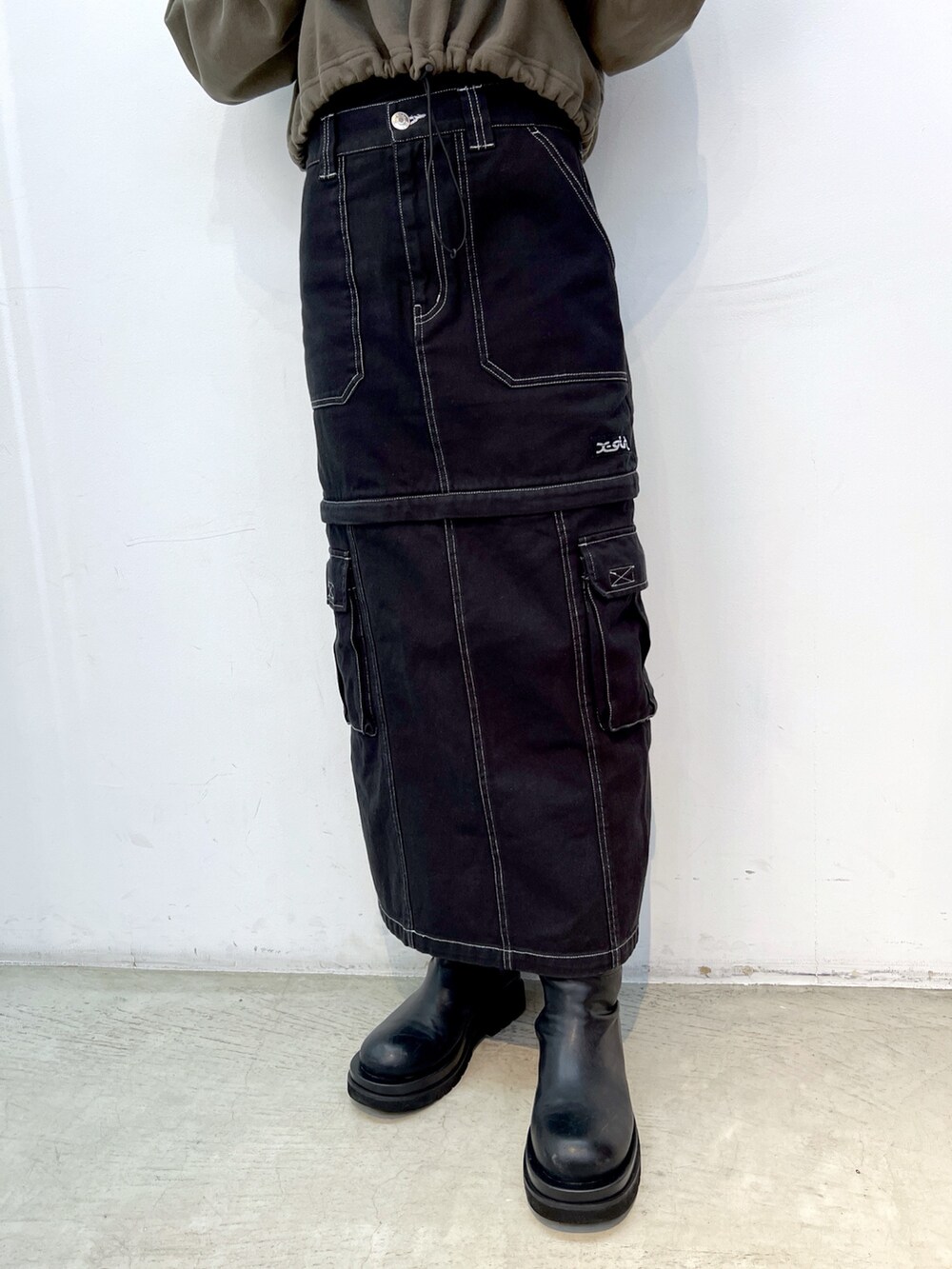 ブラック系のスカート、グリーン系のパーカー、ブラック系のショルダーバッグを着用したレディースの冬コーディネートの4枚目の写真