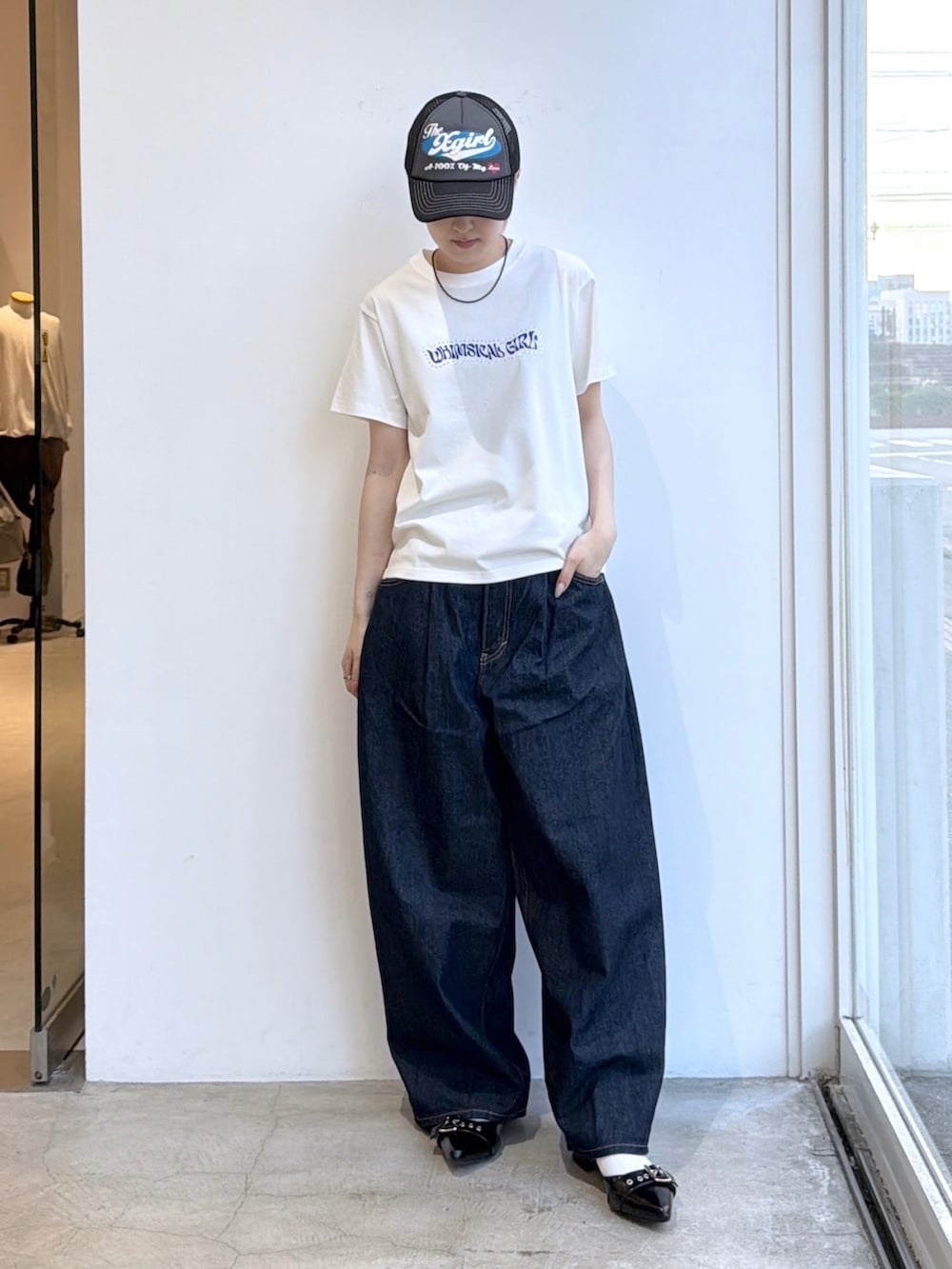 ブルー系のデニムパンツ、ホワイト系のTシャツ/カットソー、ブラック系のキャップを着用したレディースの夏コーディネートの2枚目の写真