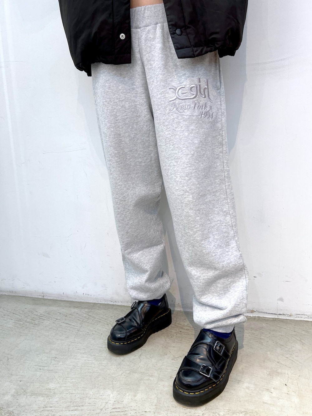 グレー系のパーカー、グレー系のスウェットパンツ、ピンク系のハンドバッグを着用したレディースの冬コーディネートの7枚目の写真