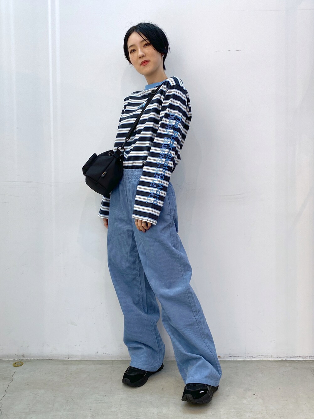 ブルー系のその他パンツ、グレー系のTシャツ/カットソー、ブラック系のショルダーバッグを着用したレディースの冬コーディネートの2枚目の写真