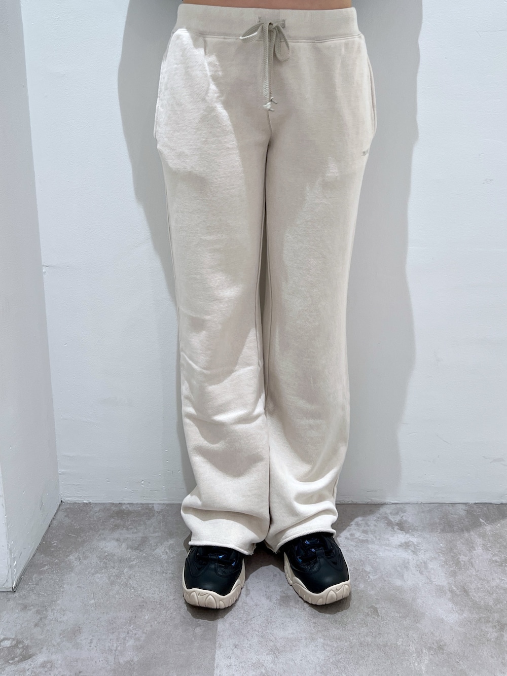 グレー系のTシャツ/カットソー、ホワイト系のスウェットパンツ、ブラック系のキャスケットを着用したレディースの秋コーディネートの4枚目の写真