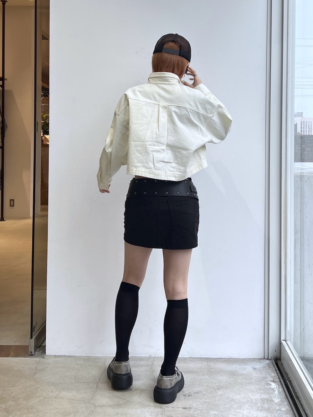 ブラック系のスカート、ホワイト系のシャツ/ブラウス、ブラック系のベルトを着用したレディースの冬コーディネートの2枚目の写真