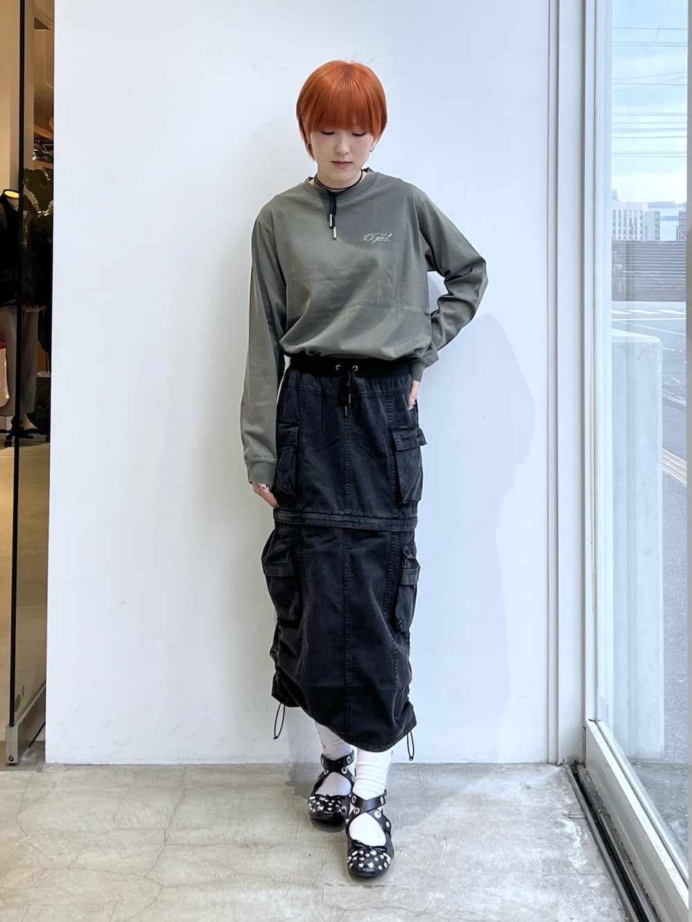 ブラック系のスカート、グリーン系のTシャツ/カットソーを着用したレディースの冬コーディネートの2枚目の写真