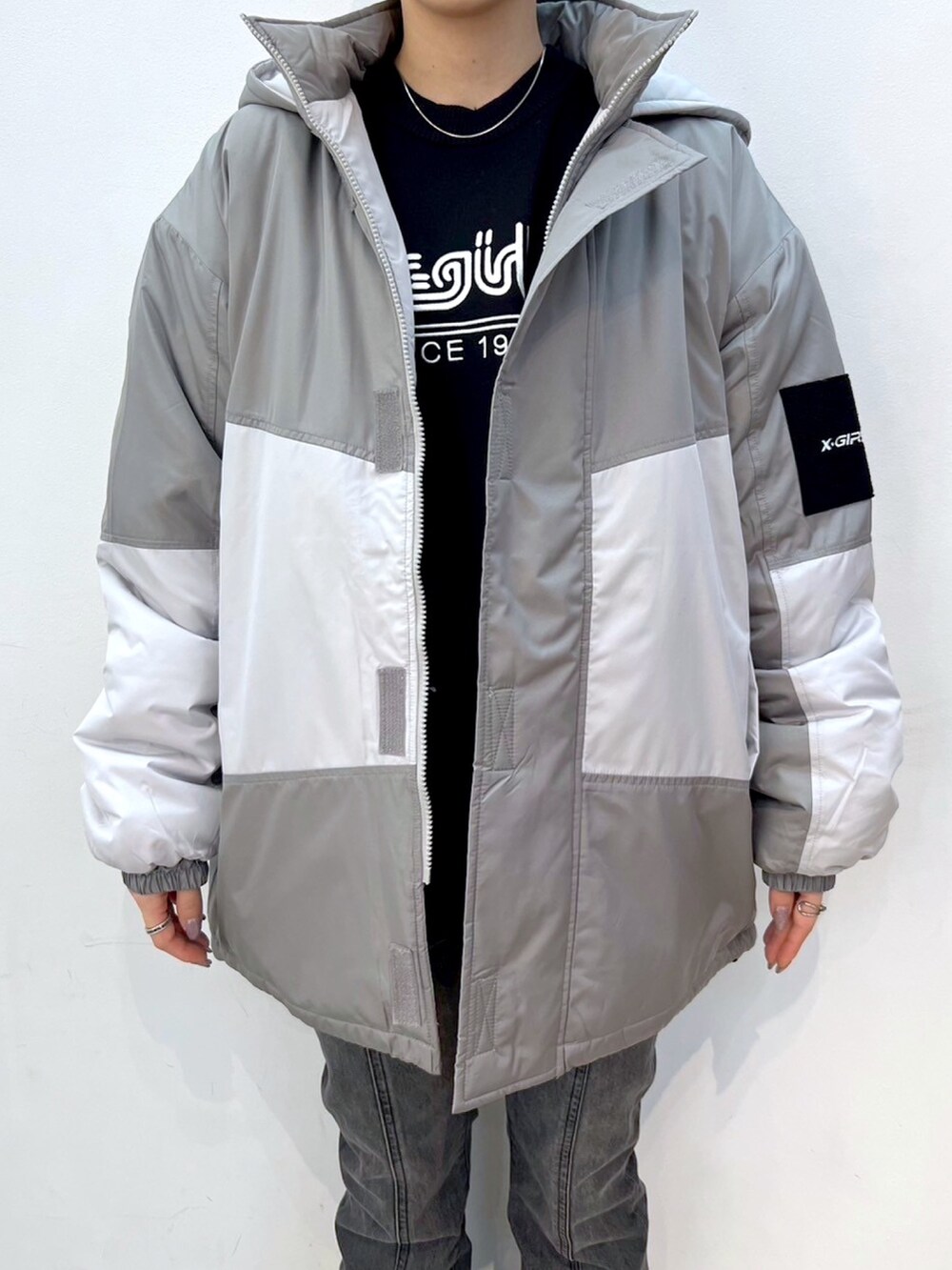 ブラック系のデニムパンツ、グレー系のマウンテンパーカー、ブラック系のニット/セーターを着用したレディースの秋コーディネートの3枚目の写真