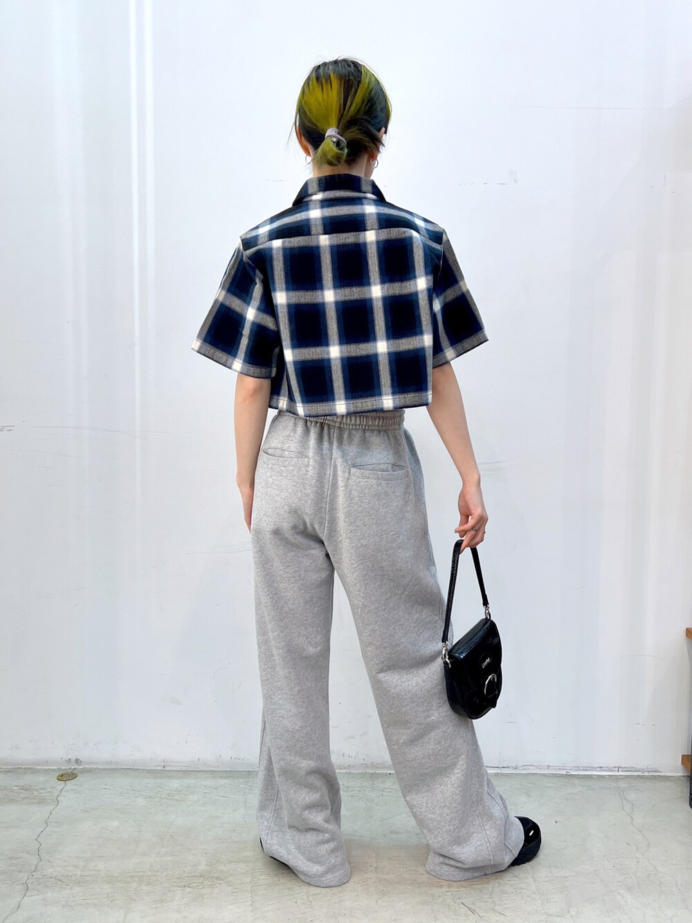 グレー系のスウェットパンツ、ブラック系のショルダーバッグ、ホワイト系のキャミソールを着用したレディースの夏コーディネートの2枚目の写真