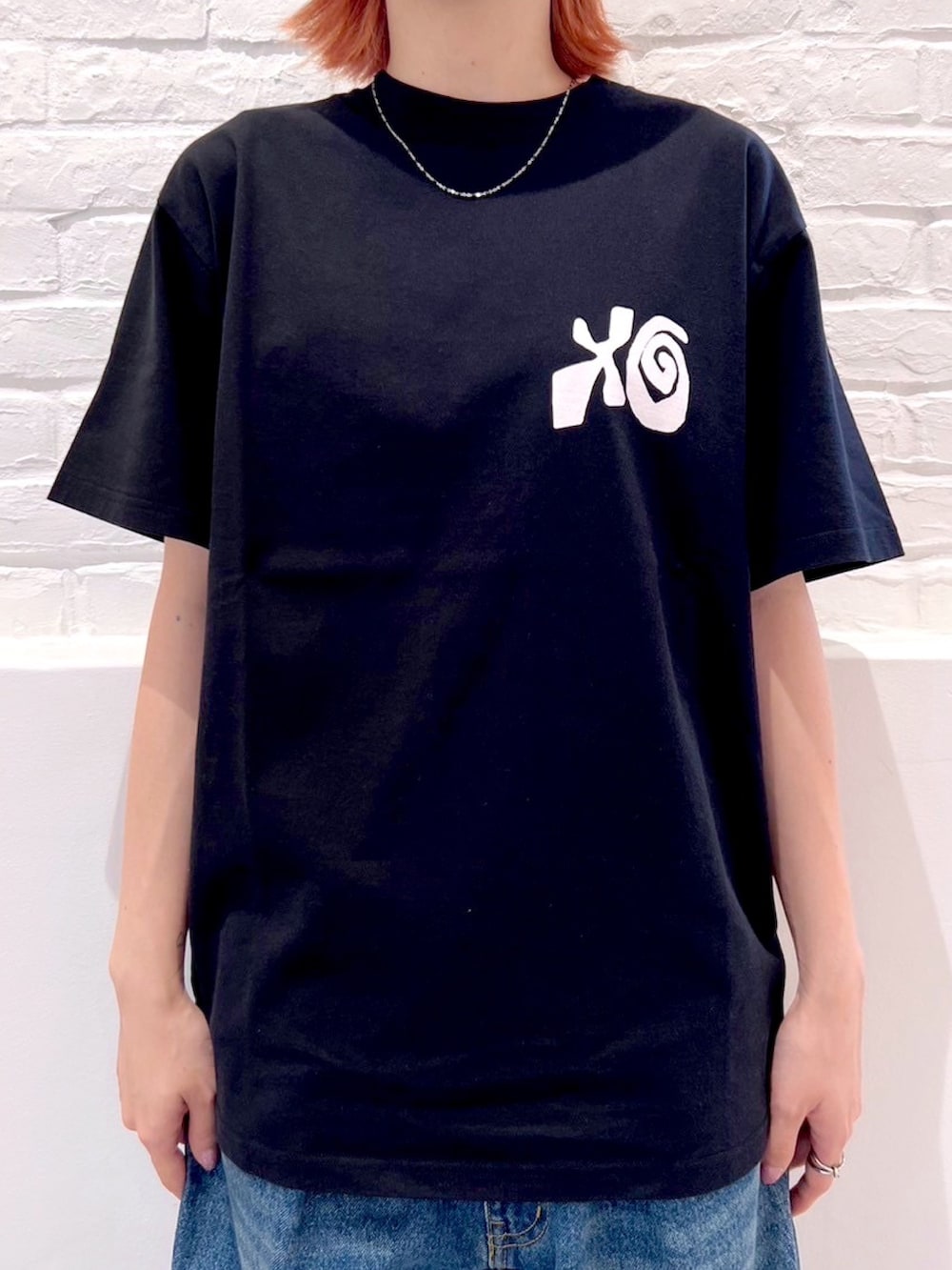 ブルー系のデニムパンツ、ブラック系のTシャツ/カットソー、ホワイト系のハットを着用したレディースの夏コーディネートの3枚目の写真