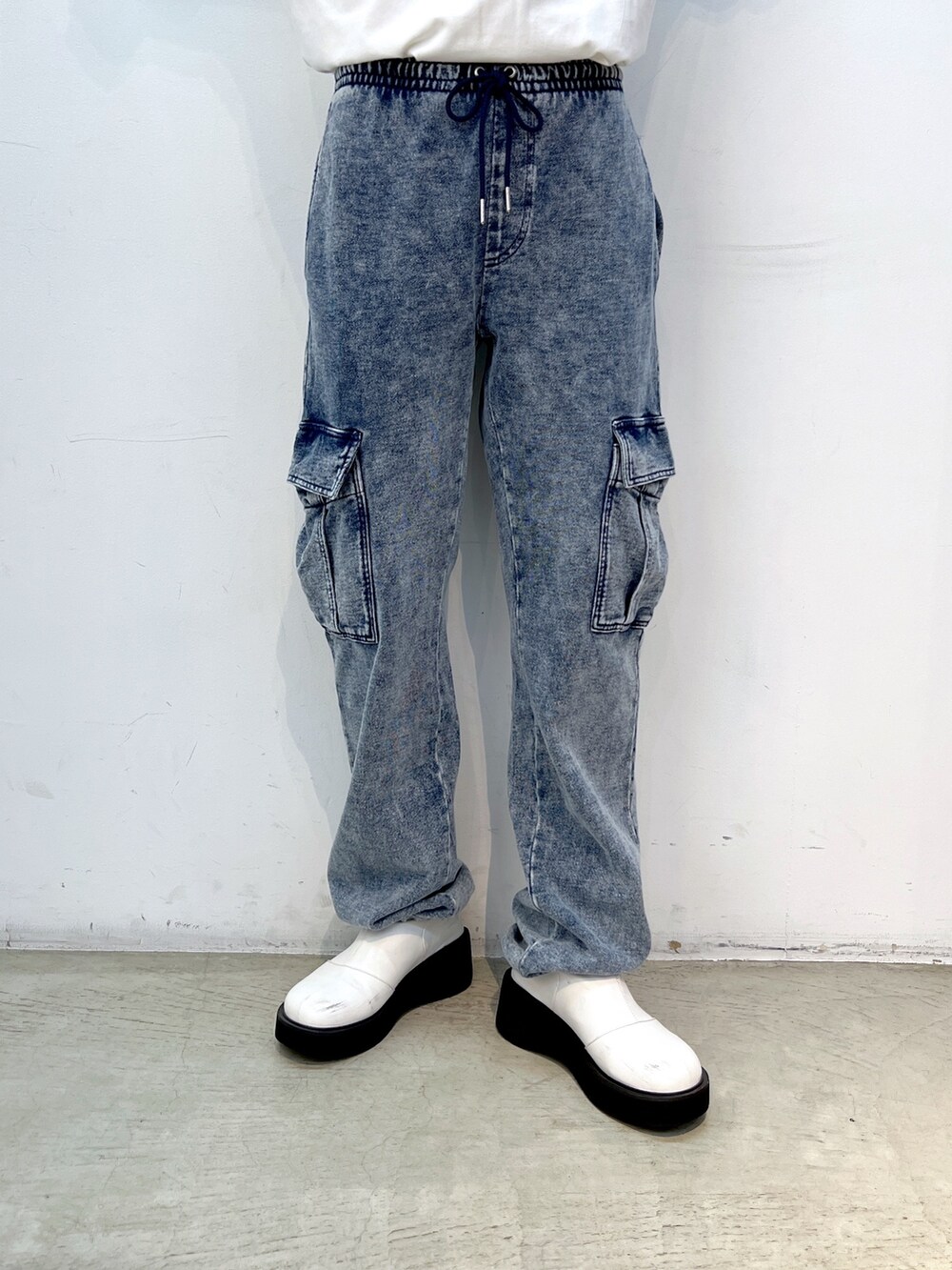 ブルー系のスウェットパンツ、グリーン系のナイロンジャケット、ホワイト系のTシャツ/カットソーを着用したレディースの秋コーディネートの9枚目の写真