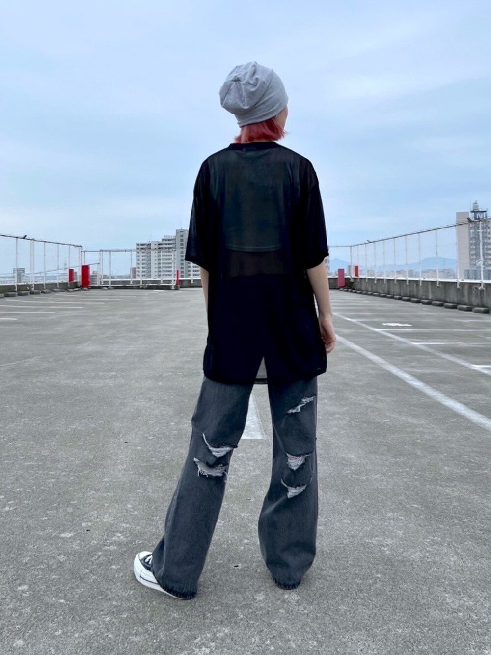 ブラック系のデニムパンツ、ブラック系のTシャツ/カットソー、ホワイト系のタンクトップを着用したレディースの夏コーディネートの2枚目の写真