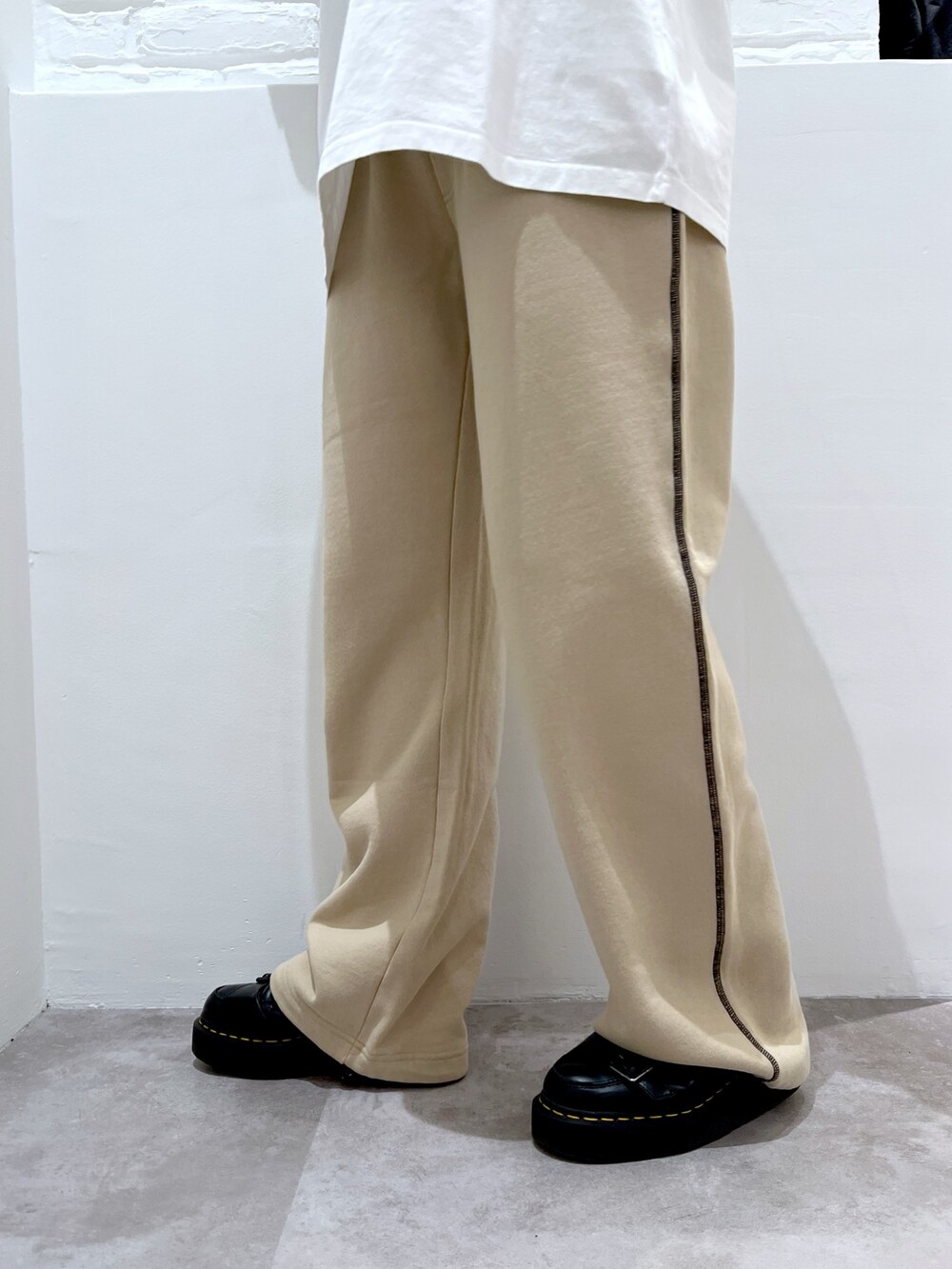 ベージュ系のスウェットパンツ、ホワイト系のTシャツ/カットソー、ベージュ系のベストを着用したレディースの春コーディネートの5枚目の写真