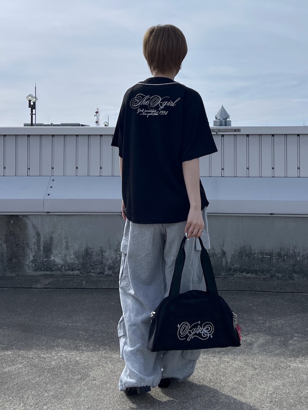 ブラック系のハンドバッグ、グレー系のスウェットパンツ、ブラック系のシャツ/ブラウスを着用したレディースの春コーディネートの2枚目の写真