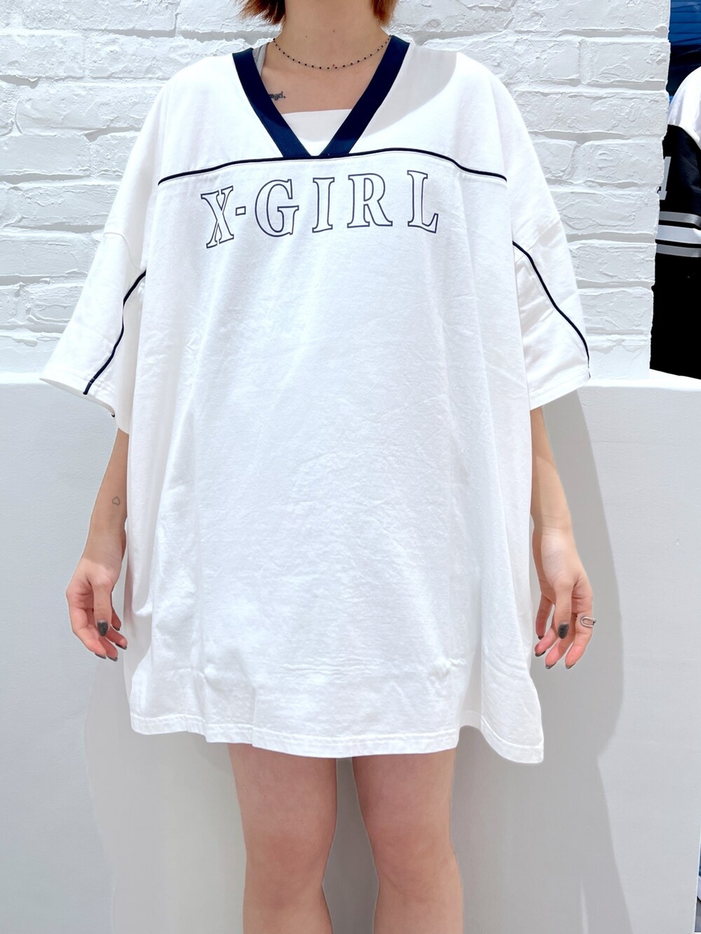 ホワイト系のワンピース、ピンク系のショルダーバッグ、ホワイト系のハットを着用したレディースの春コーディネートの3枚目の写真