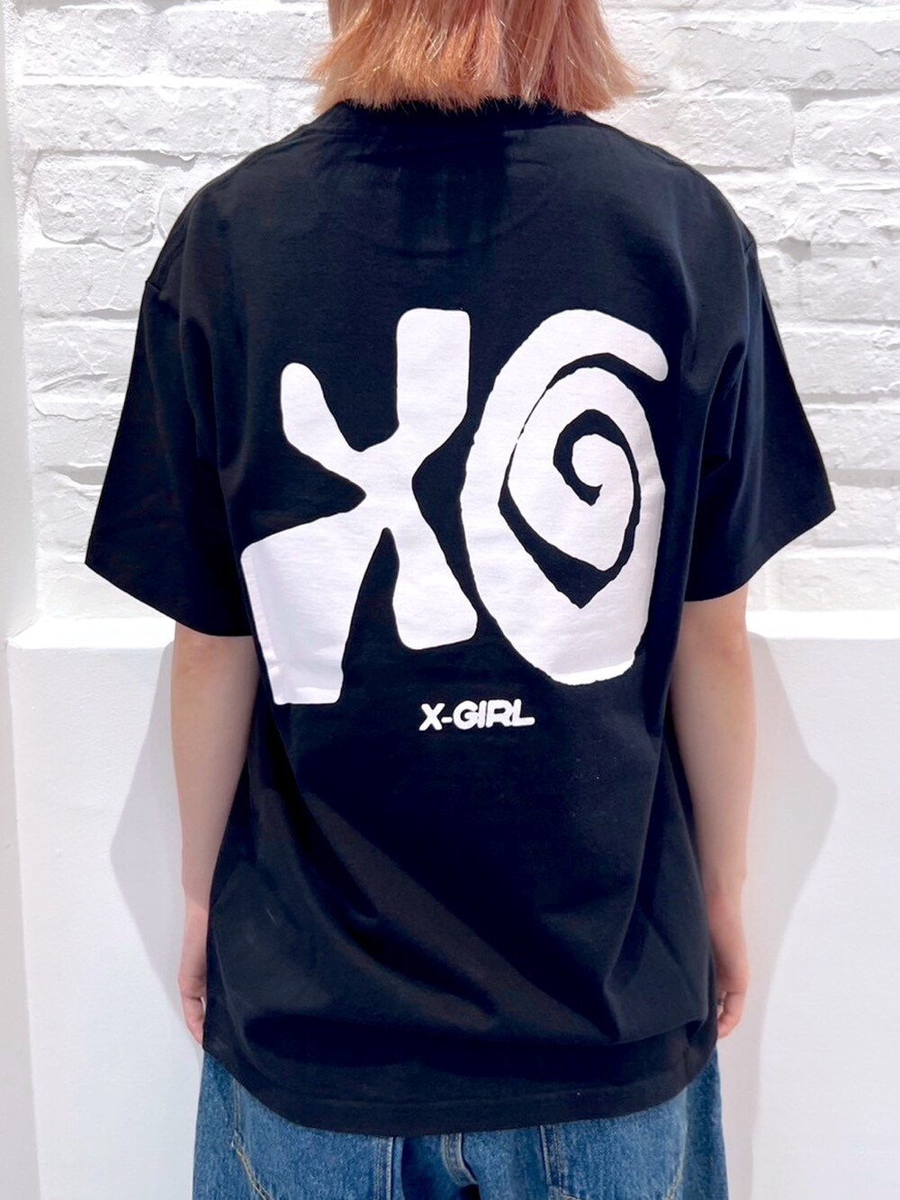 ブルー系のデニムパンツ、ブラック系のTシャツ/カットソー、ホワイト系のハットを着用したレディースの夏コーディネートの4枚目の写真