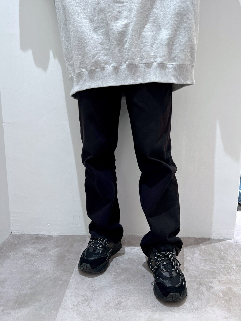 グレー系のスウェット、ブラック系のデニムパンツ、ブルー系のショルダーバッグを着用したレディースの春コーディネートの5枚目の写真