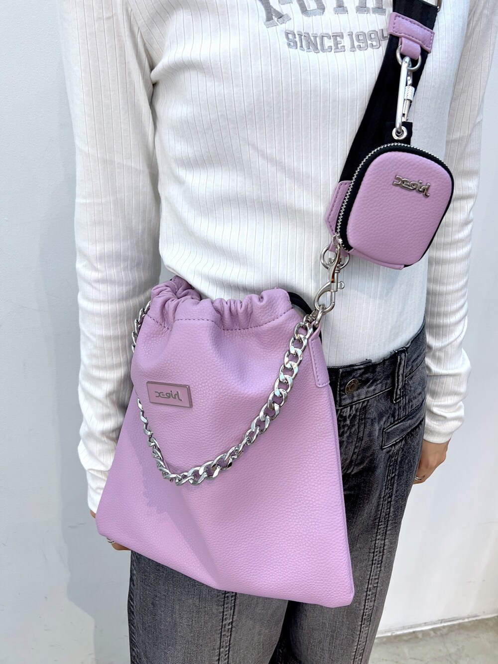 ホワイト系のTシャツ/カットソー、パープル系のショルダーバッグ、ブラック系のデニムパンツを着用したレディースの秋コーディネートの7枚目の写真